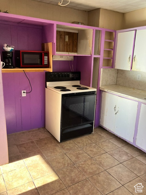 Kitchen with light tile patterned floors and white electric stove