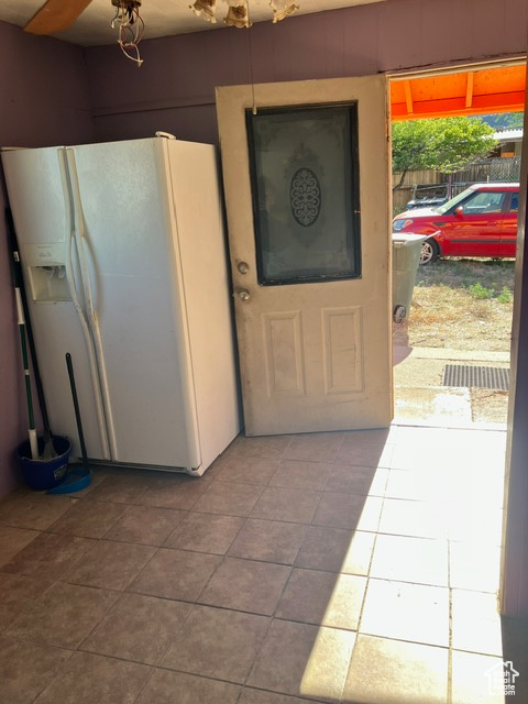 Kitchen featuring tile patterned floors and white fridge with ice dispenser