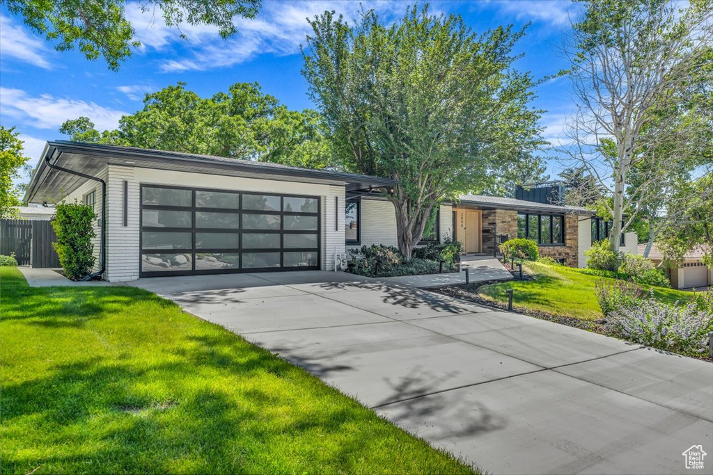 Mid-century home featuring driveway and an attached garage