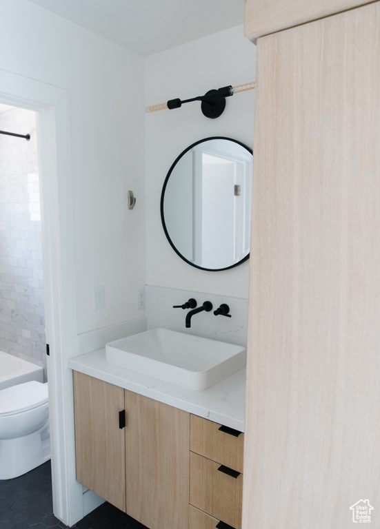 Bathroom with tile patterned flooring, vanity, and toilet