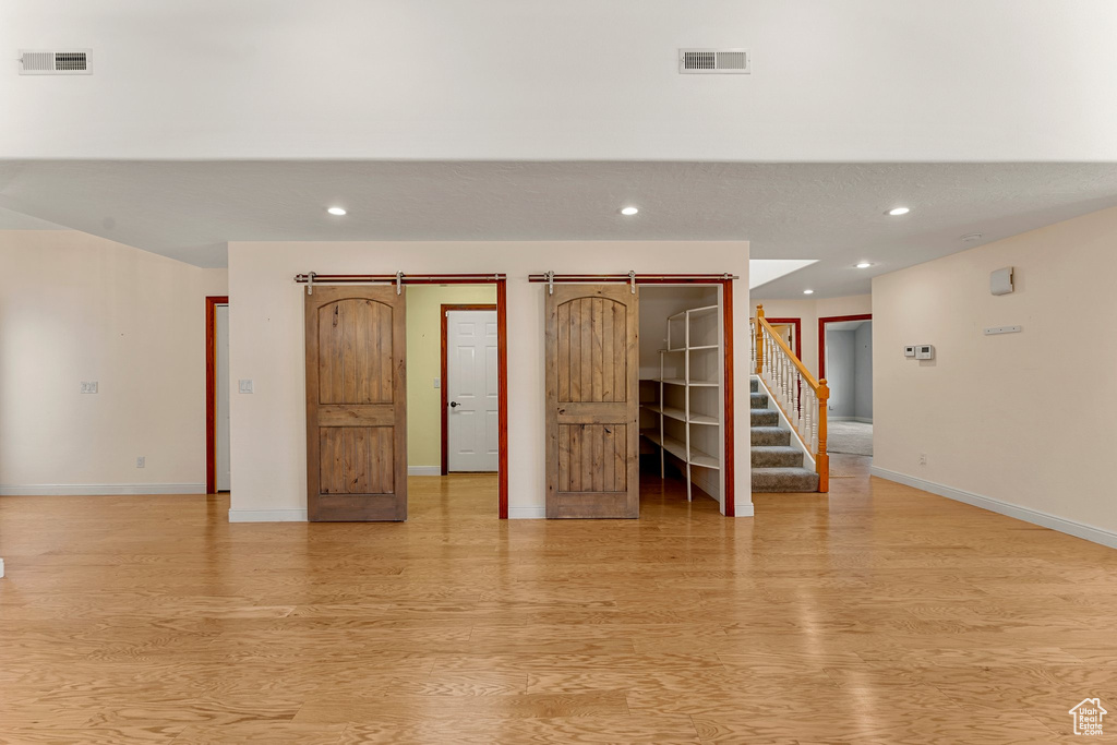 Spare room with light wood-style floors, baseboards, recessed lighting, and stairway