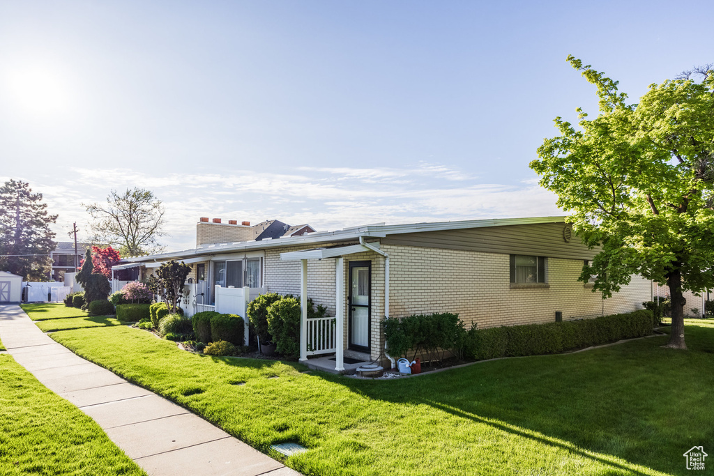 Single story home with brick siding, a front lawn, and a chimney