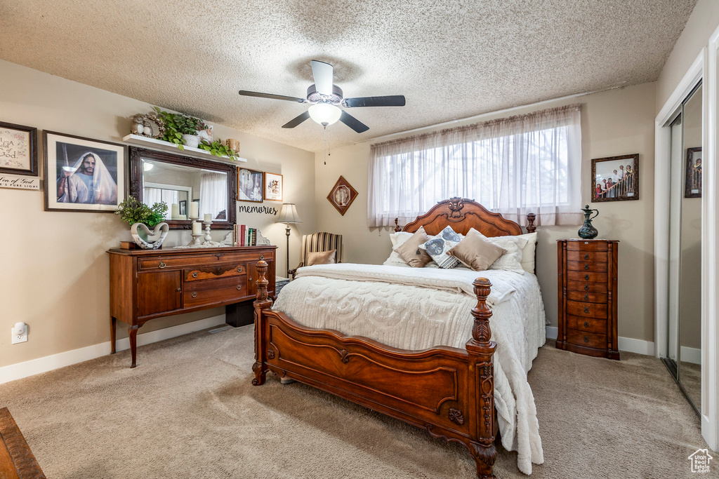 Bedroom with carpet flooring, a ceiling fan, a textured ceiling, and baseboards