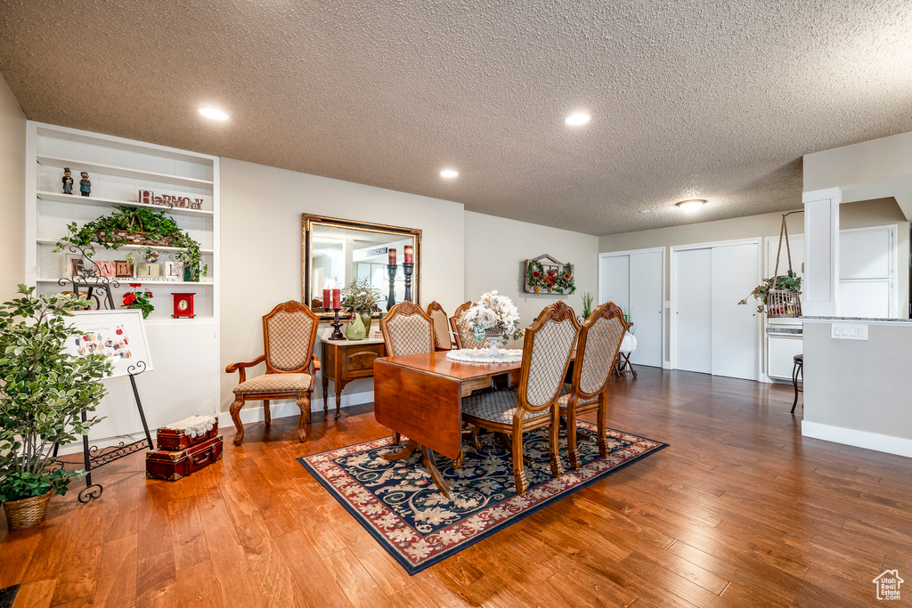 Dining space with recessed lighting, a textured ceiling, and wood finished floors