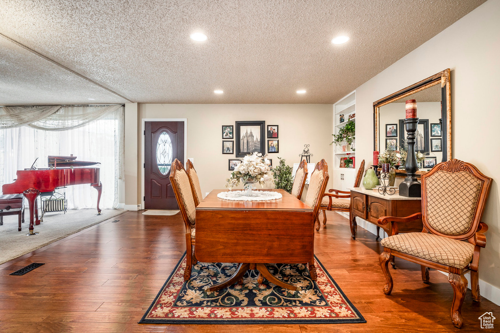 Dining room with recessed lighting, a textured ceiling, and wood finished floors