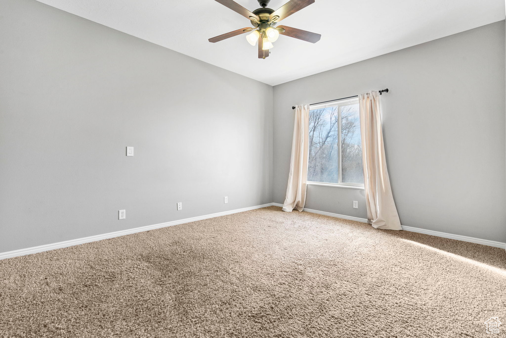 Carpeted empty room featuring ceiling fan