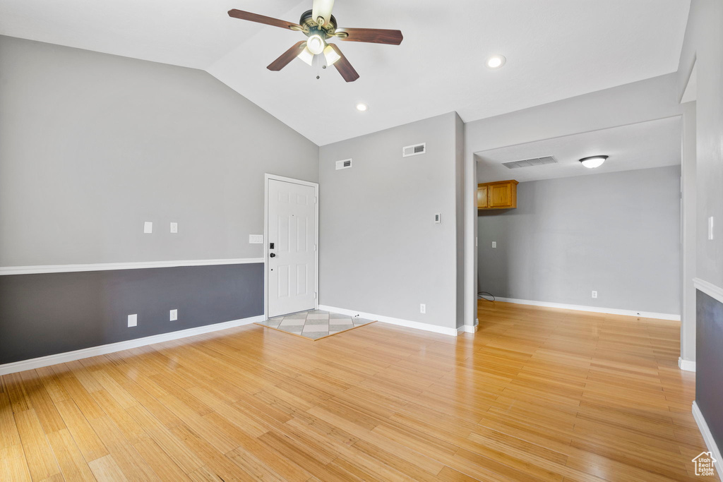 Unfurnished living room with light wood-type flooring, ceiling fan, and lofted ceiling