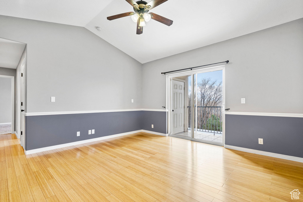 Empty room featuring ceiling fan, lofted ceiling, and light wood-type flooring