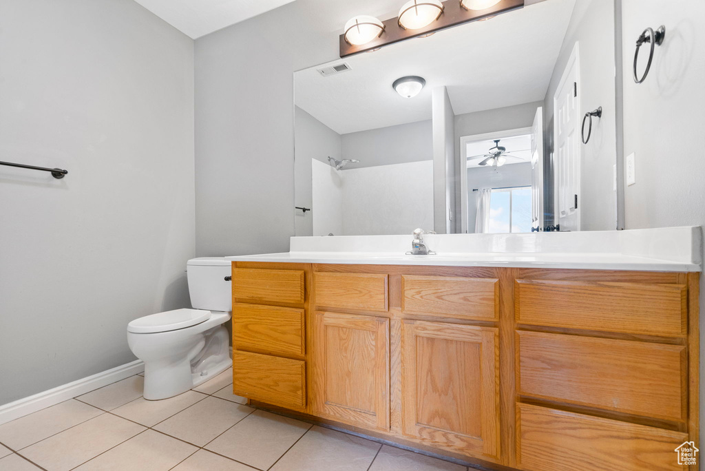 Bathroom featuring ceiling fan, walk in shower, tile patterned flooring, toilet, and vanity