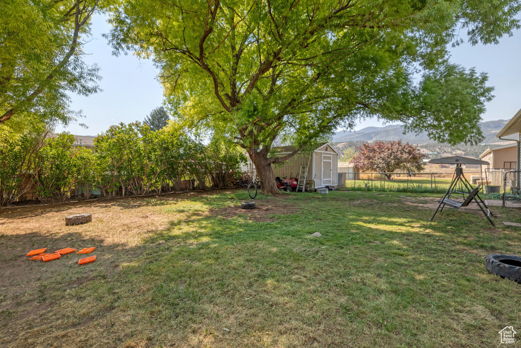View of yard featuring a mountain view and a storage unit