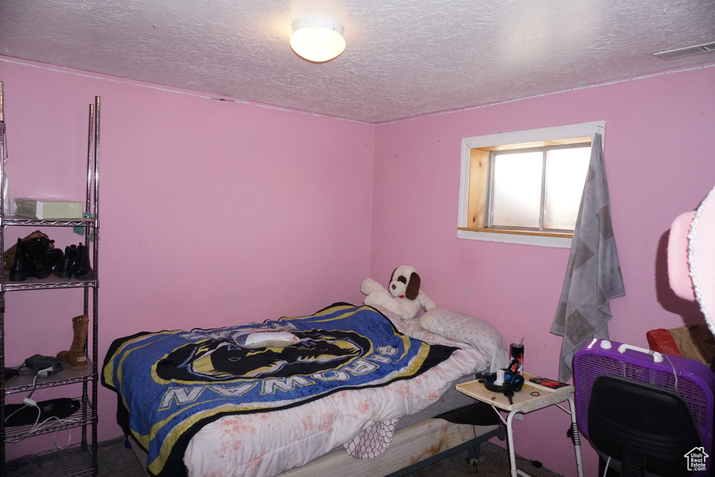 Bedroom featuring visible vents and a textured ceiling