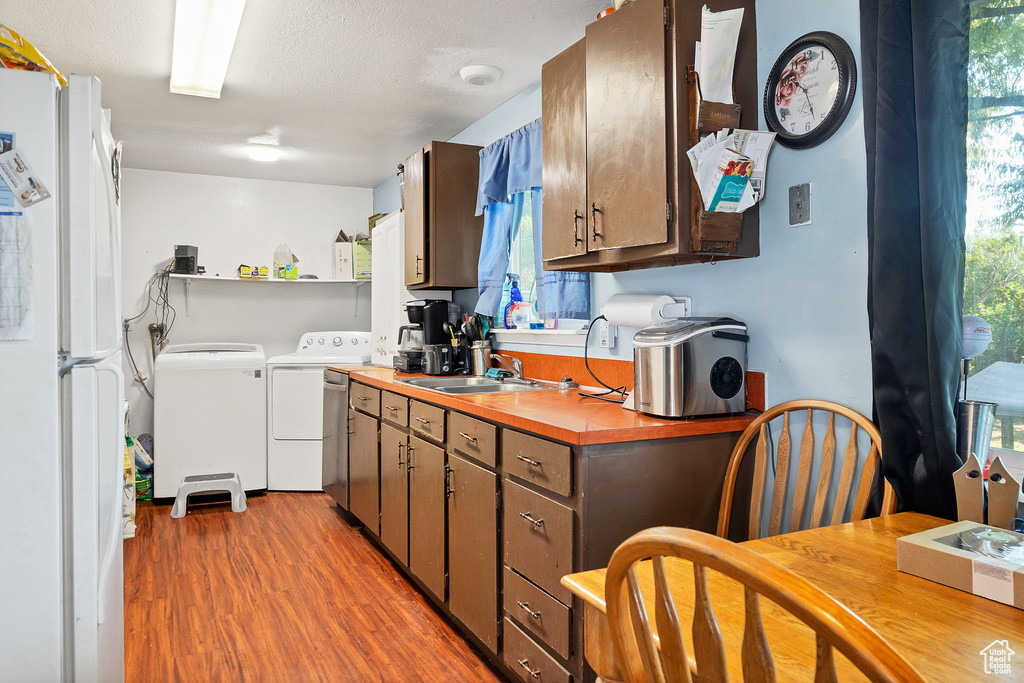 Kitchen featuring sink, washer and dryer, plenty of natural light, and white refrigerator