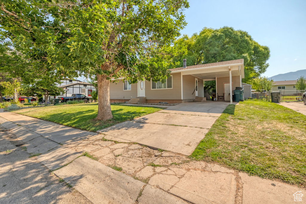 View of front of property with a front lawn and a carport