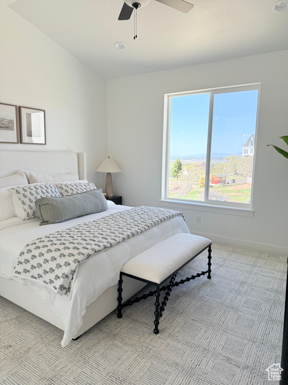 Bedroom featuring light carpet, baseboards, and ceiling fan