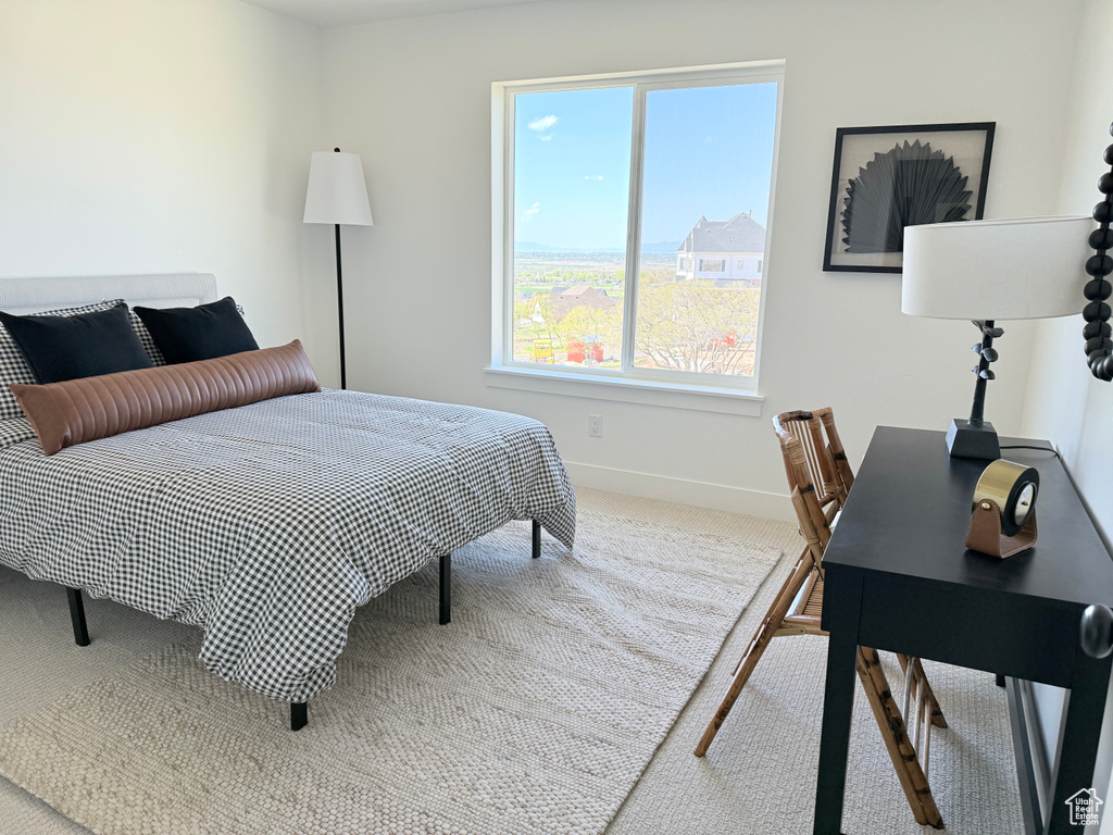 Carpeted bedroom with baseboards and an office area