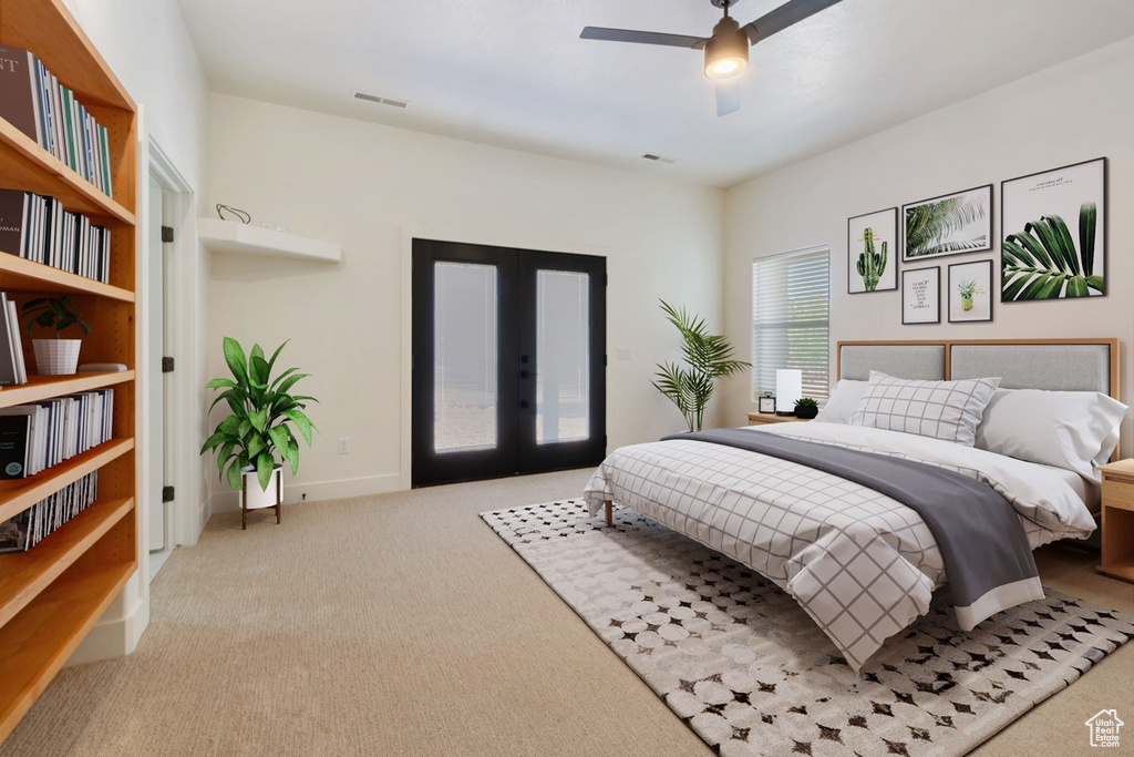 Carpeted bedroom with access to outside, ceiling fan, and french doors