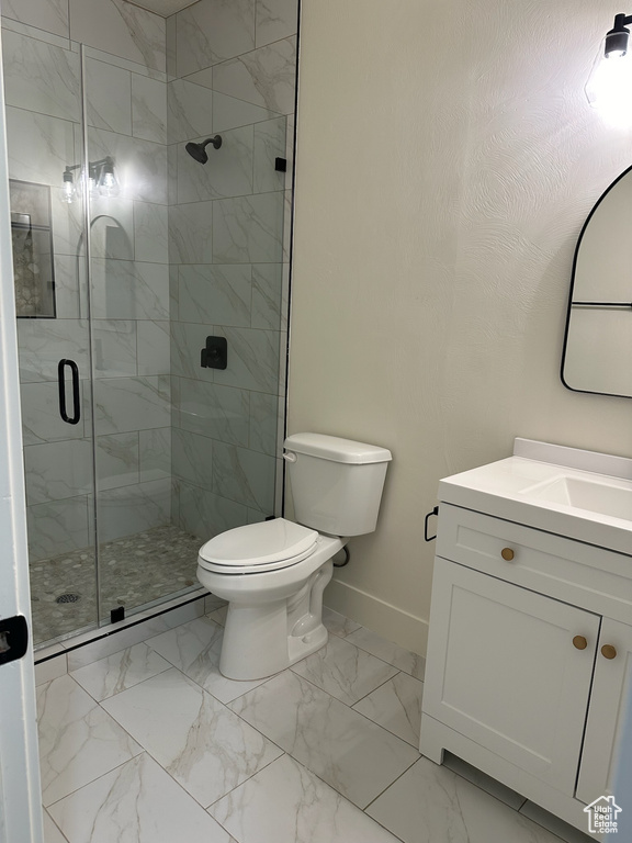 Bathroom with a shower with door, vanity, and toilet