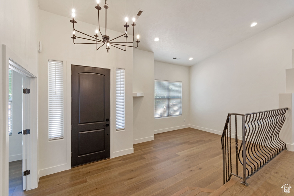 Foyer entrance with a chandelier and light wood-type flooring