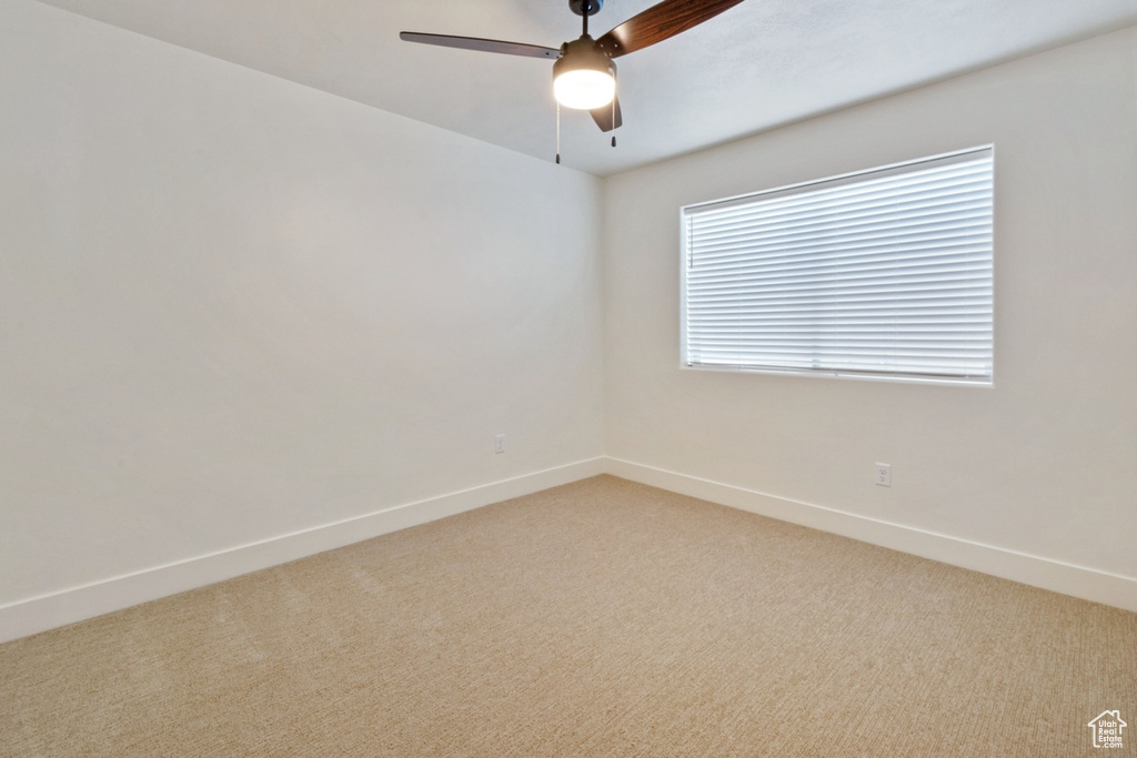 Carpeted spare room with ceiling fan