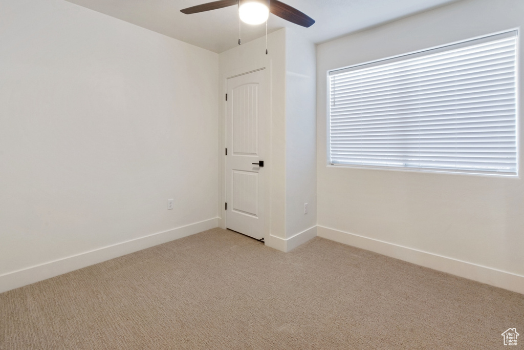 Spare room with ceiling fan and light colored carpet