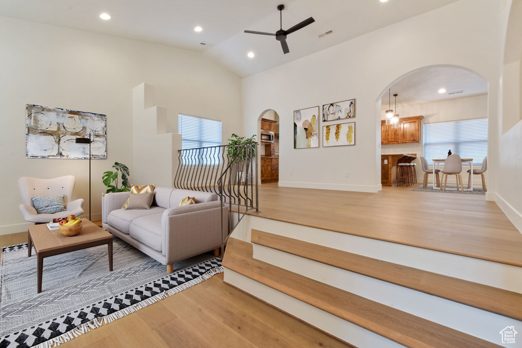 Living room featuring wood-type flooring, ceiling fan, and lofted ceiling