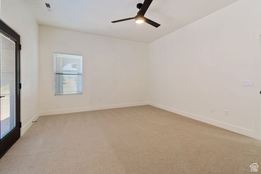 Carpeted empty room featuring ceiling fan