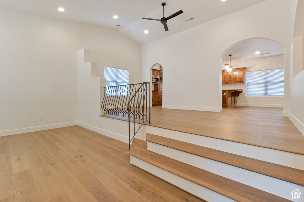 Stairs with hardwood / wood-style flooring, vaulted ceiling, and ceiling fan