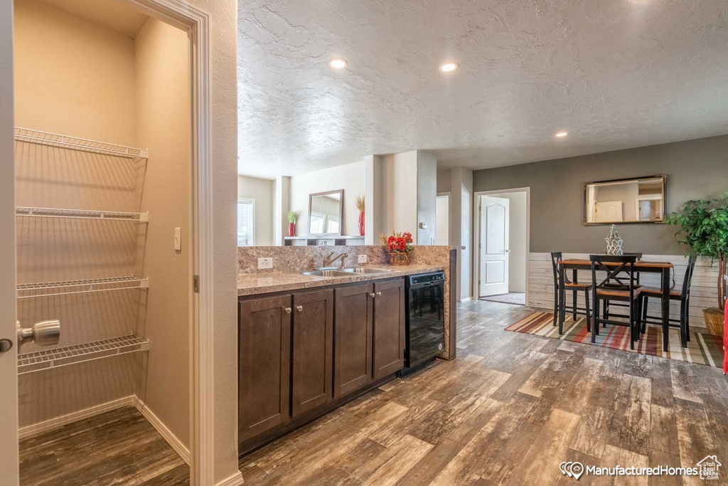 Kitchen featuring hardwood / wood-style floors, sink, a textured ceiling, dark brown cabinets, and beverage cooler