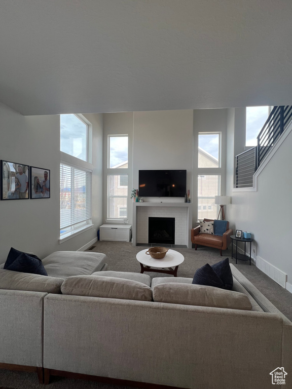 Carpeted living room with a brick fireplace