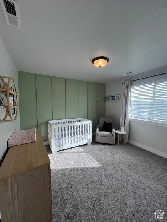 Bedroom featuring carpet and a nursery area