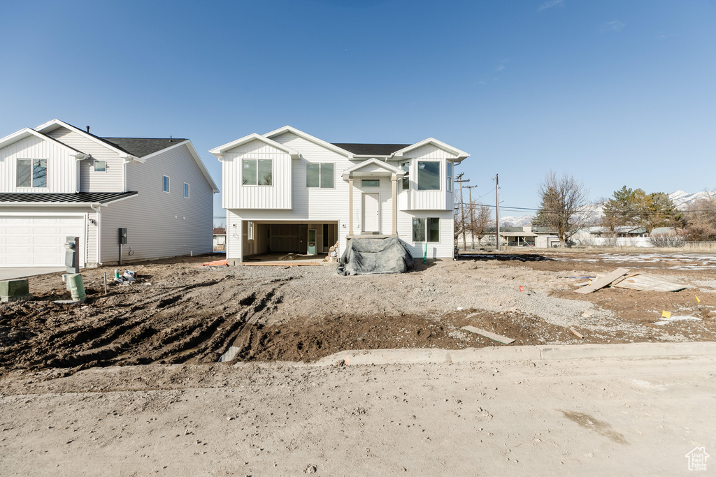 Raised ranch featuring board and batten siding and an attached garage