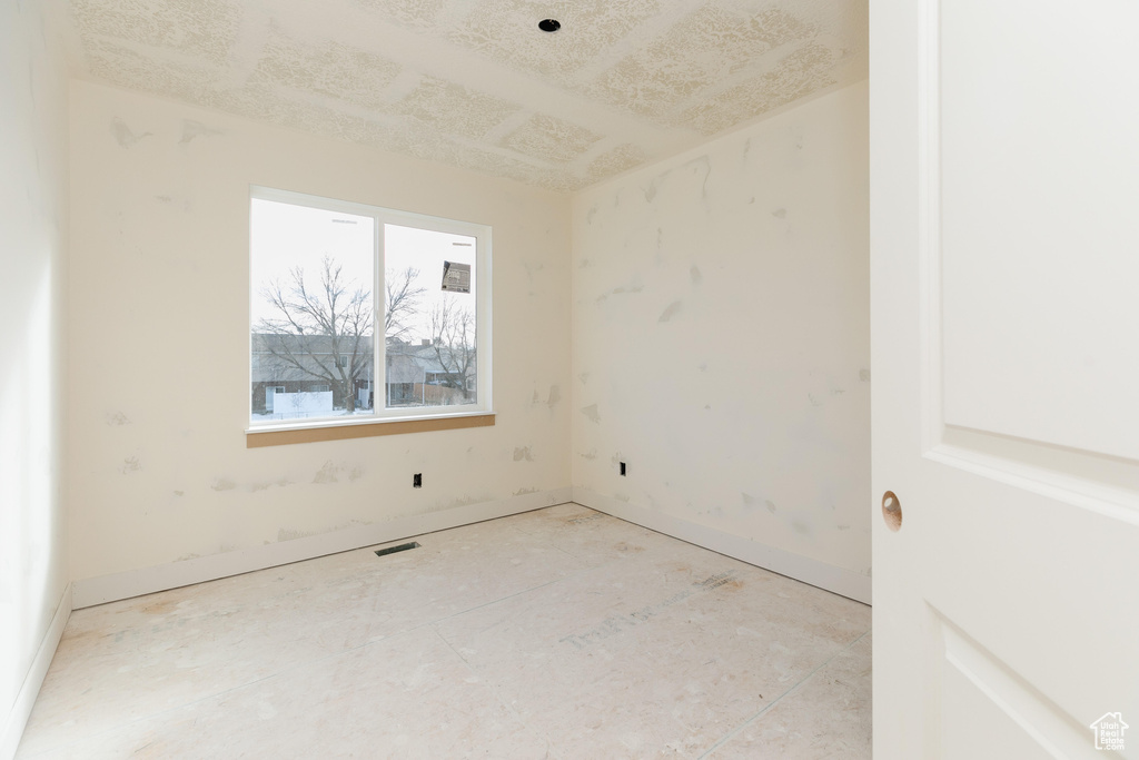 Unfurnished room featuring visible vents