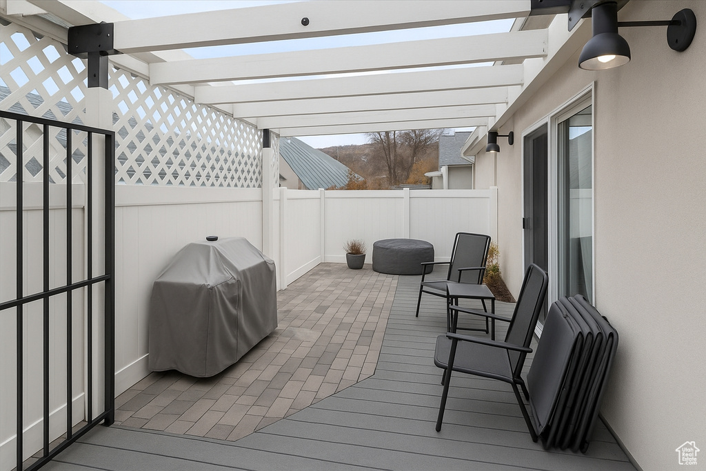 Wooden deck featuring a pergola, grilling area, a fenced backyard, and a patio area
