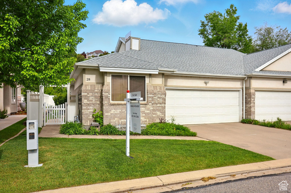 View of front of property with concrete driveway, a garage, stucco siding, a shingled roof, and a gate