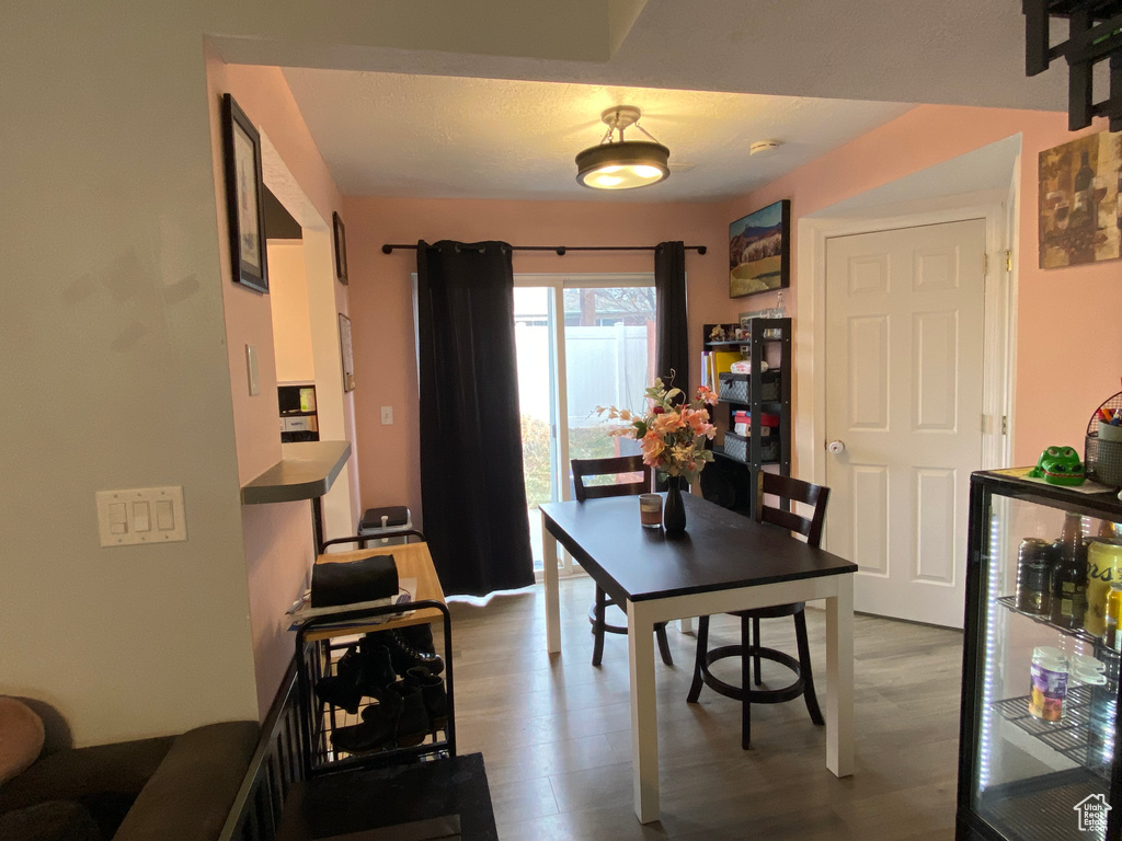 Dining area with hardwood / wood-style flooring and wine cooler