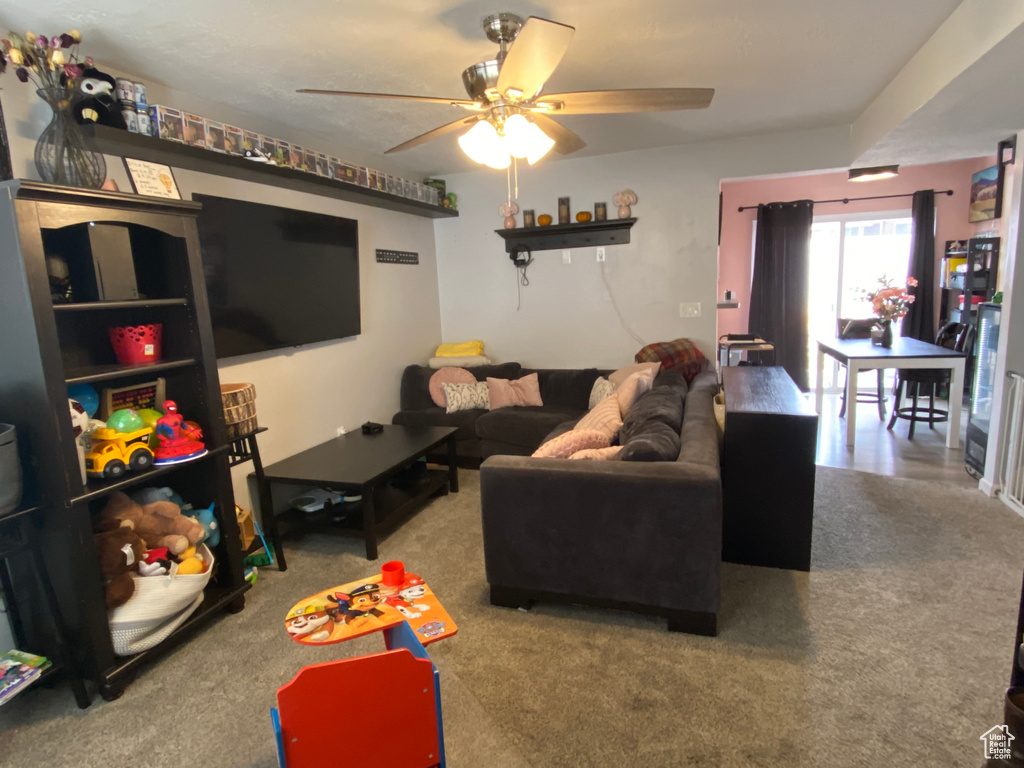 Living room featuring ceiling fan and carpet floors