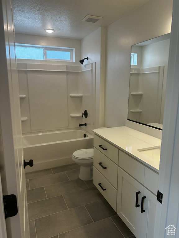 Full bathroom with vanity, shower / bathtub combination, a textured ceiling, and tile patterned floors