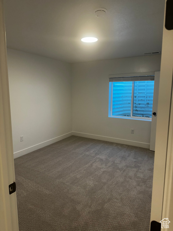 Unfurnished room featuring carpet and a smoke detector