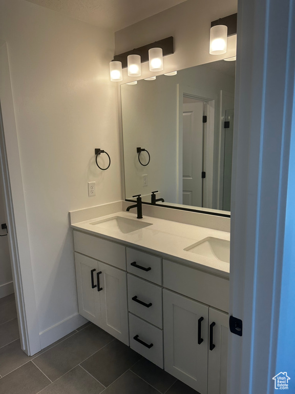 Bathroom with double vanity and tile patterned flooring
