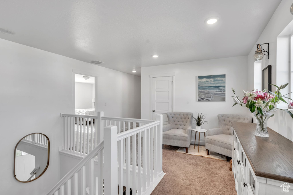 Corridor featuring light colored carpet