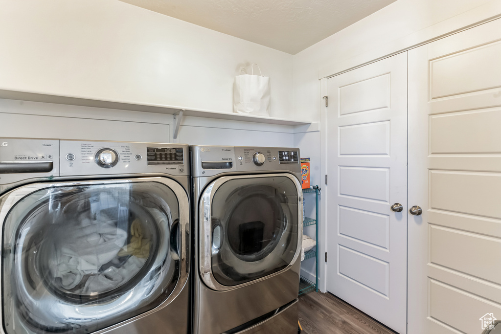 Laundry room with separate washer and dryer and dark hardwood / wood-style flooring