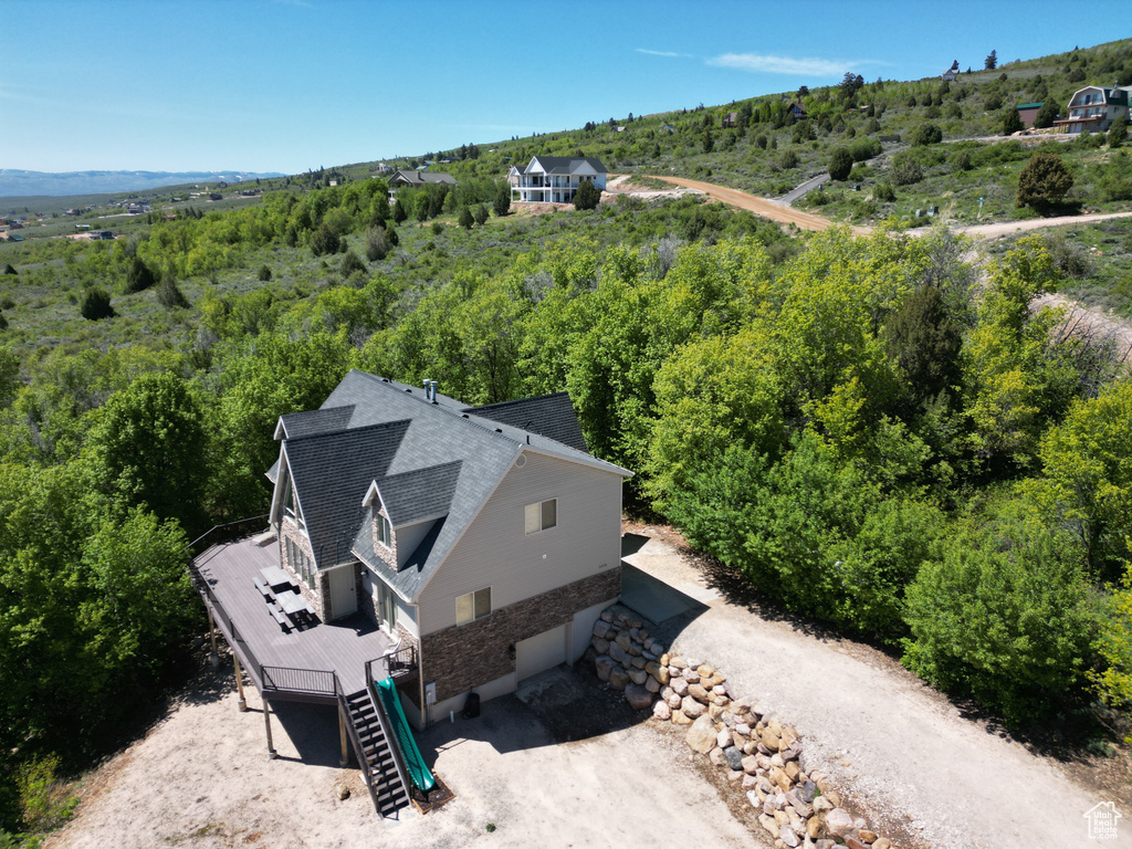 Aerial view of property and surrounding area with a forest