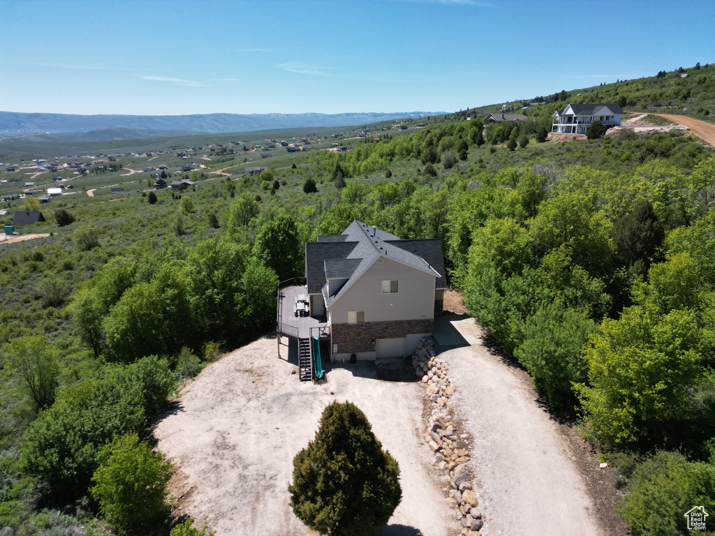 View of subject property with a mountainous background and a heavily wooded area