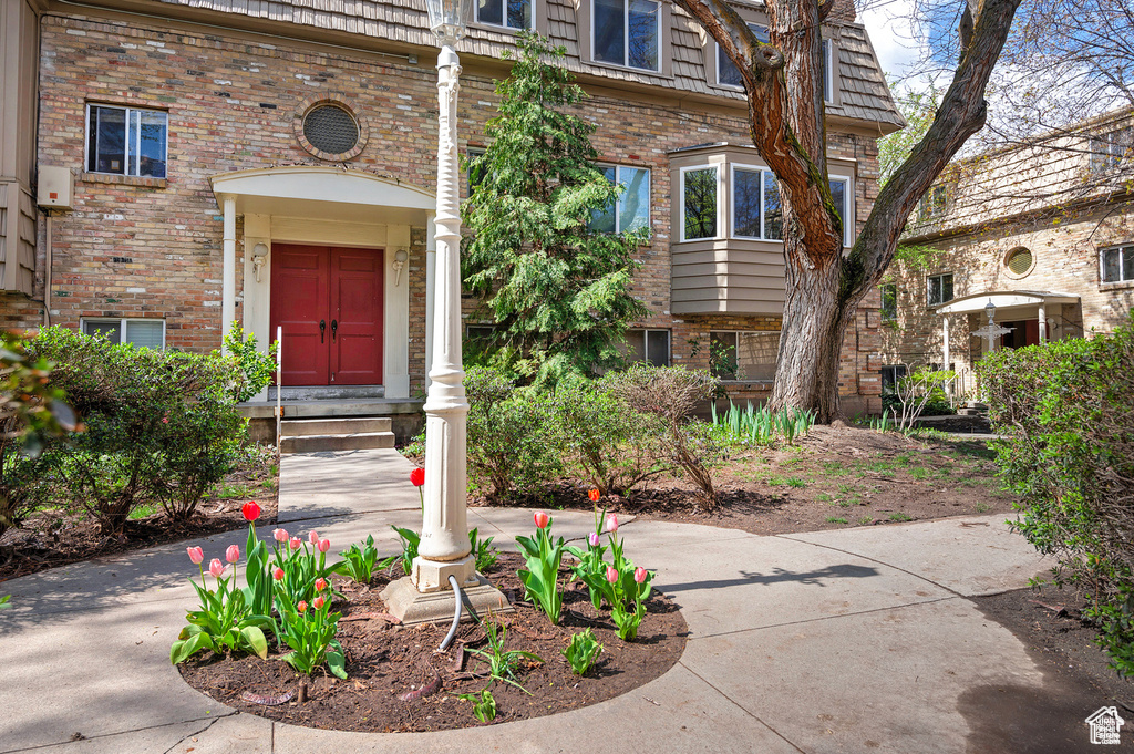 Entrance to property featuring brick siding and mansard roof