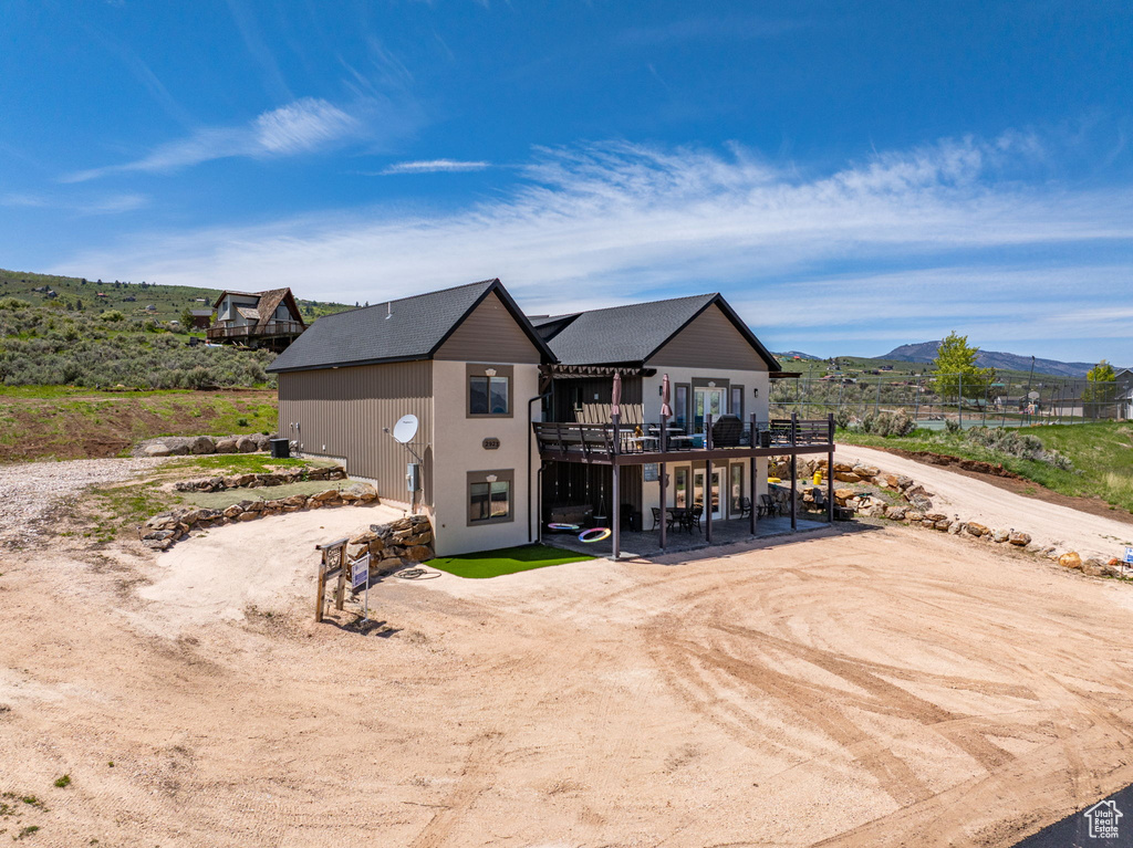 Rear view of house featuring a patio and a deck with mountain view