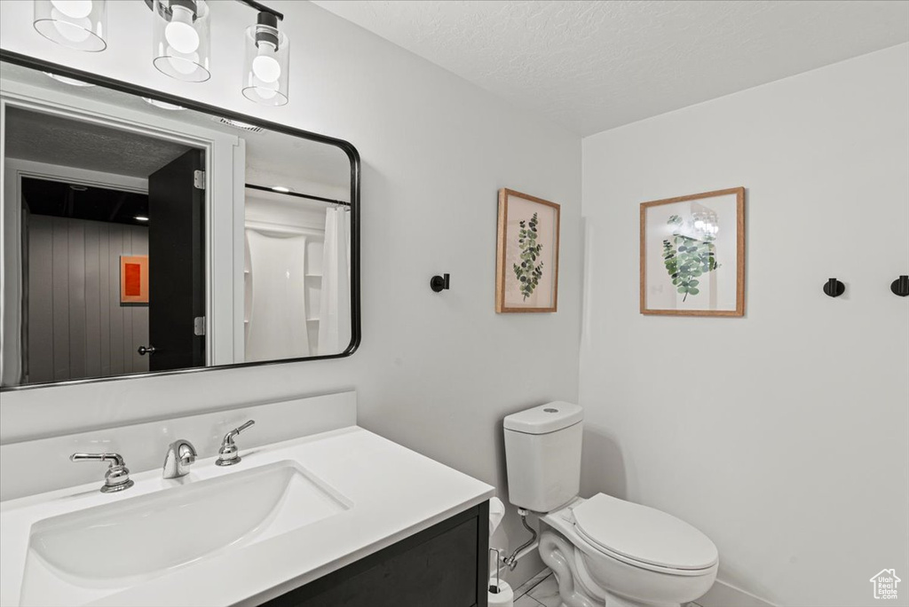 Bathroom featuring vanity, toilet, and a textured ceiling