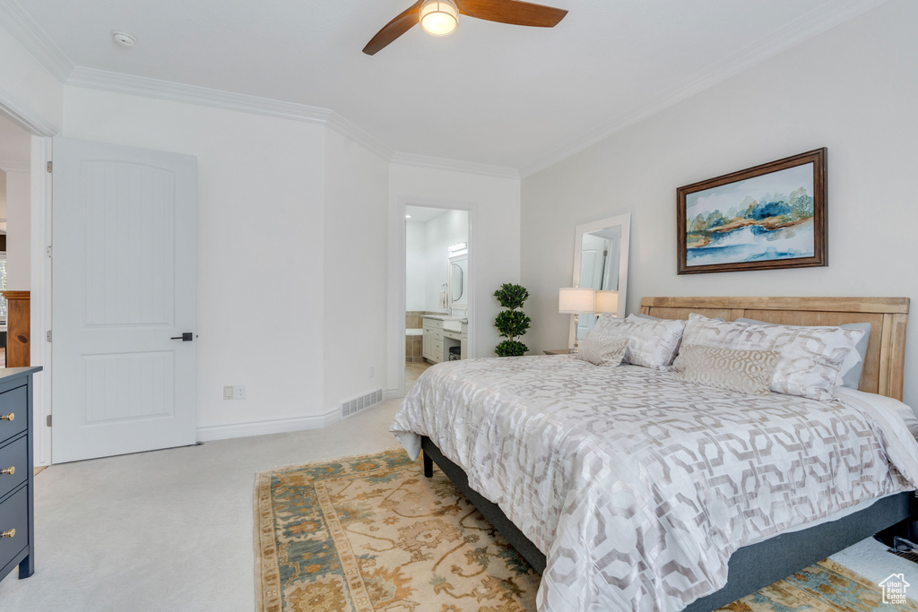 Bedroom featuring connected bathroom, ceiling fan, crown molding, and light carpet