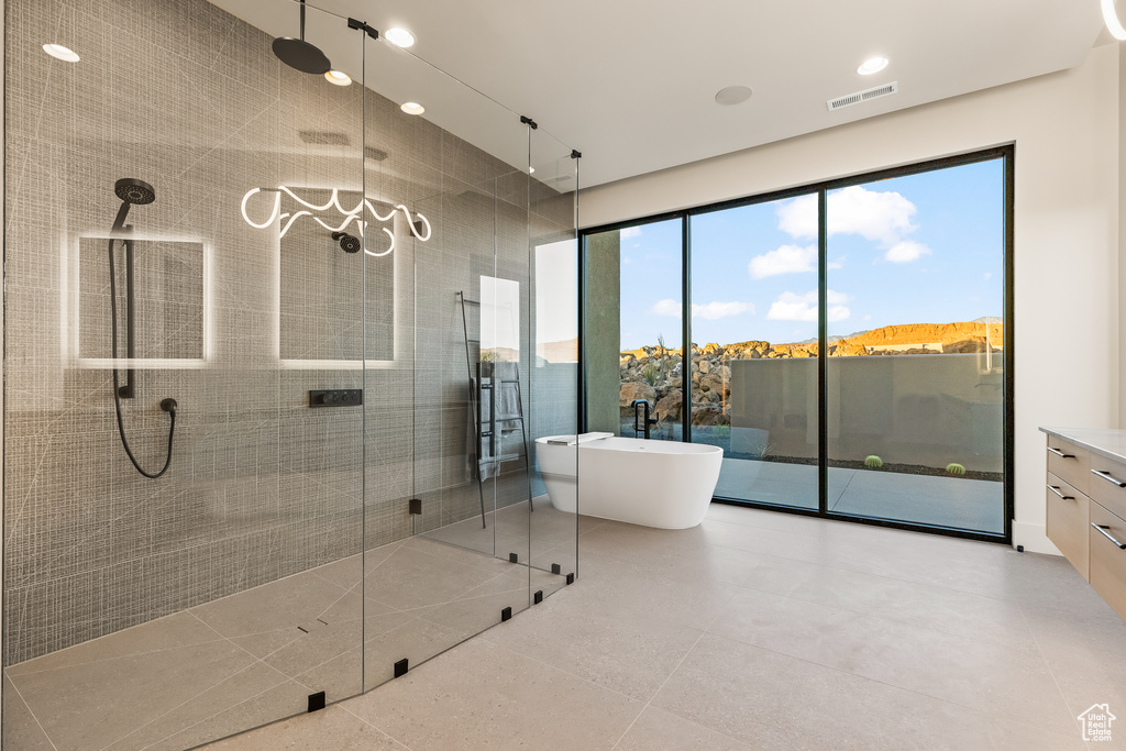 Bathroom with tile patterned floors, a mountain view, shower with separate bathtub, and vanity