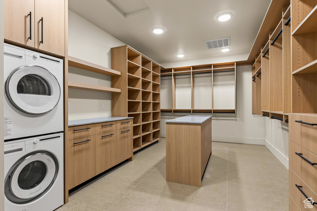 Walk in closet featuring stacked washing maching and dryer