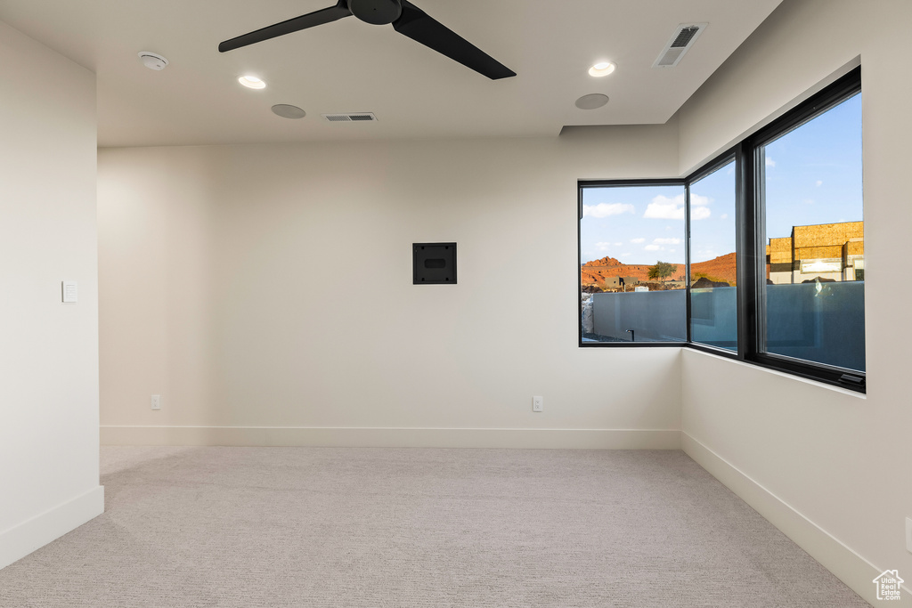 Carpeted spare room featuring ceiling fan